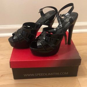Black patent leather platform sandals.